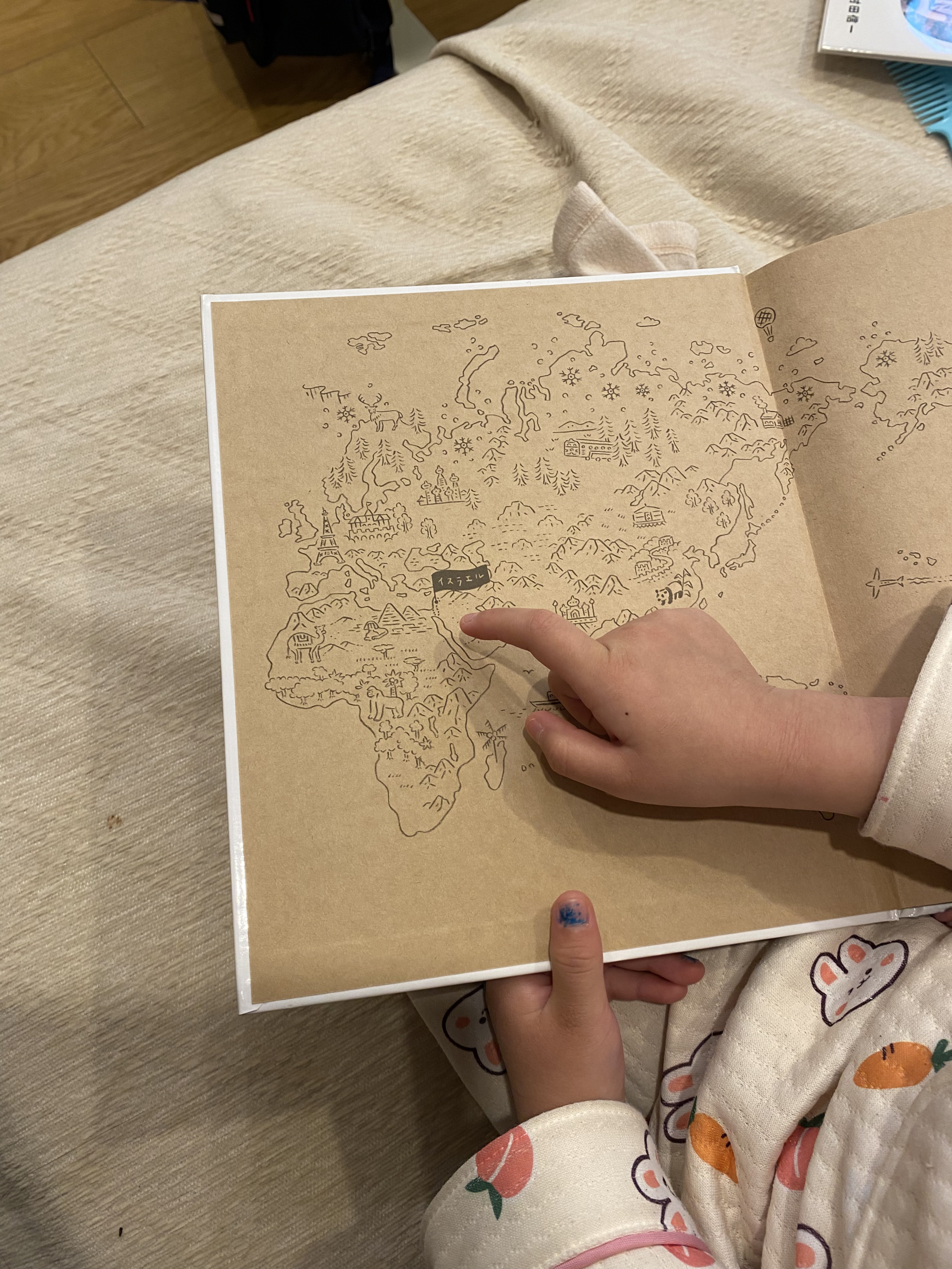 Child pointing to Israel on a world map while learning about countries